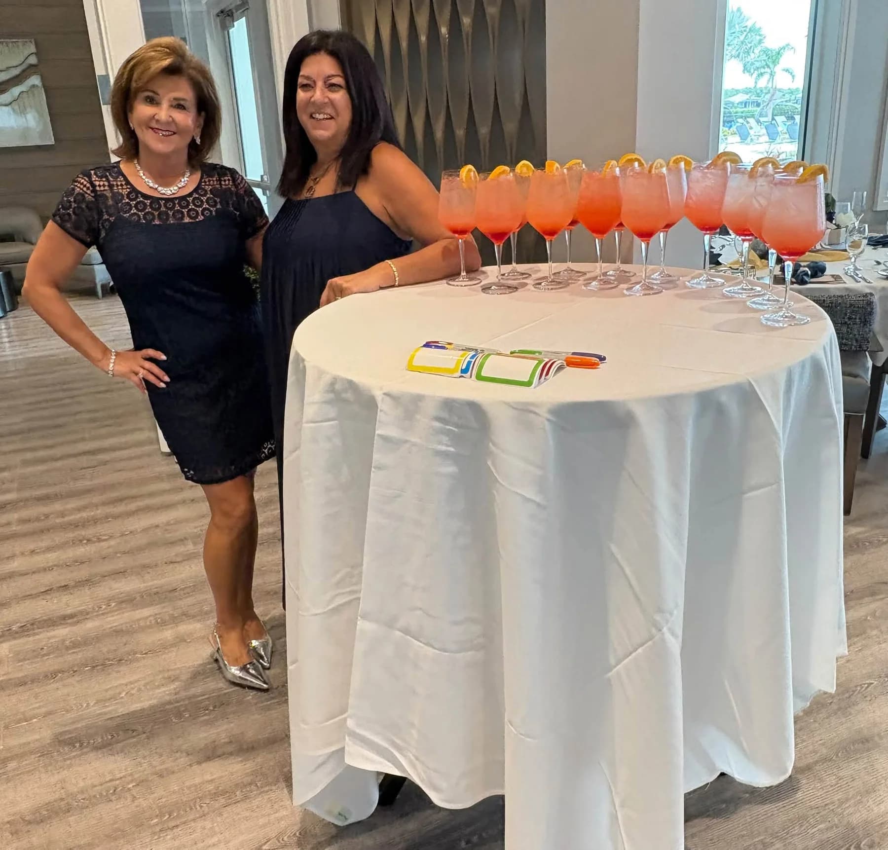Two luncheon guests beside a table of colorful welcome drinks