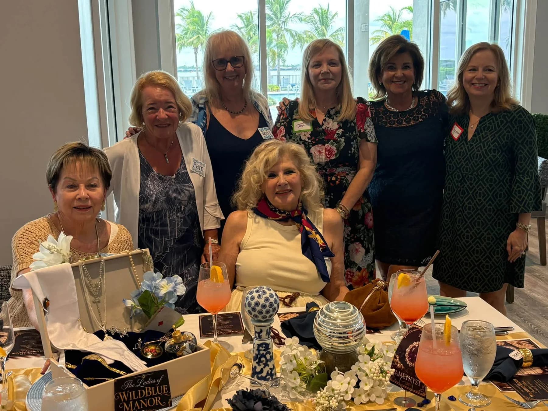 Luncheon guests smiling together around a decorated table
