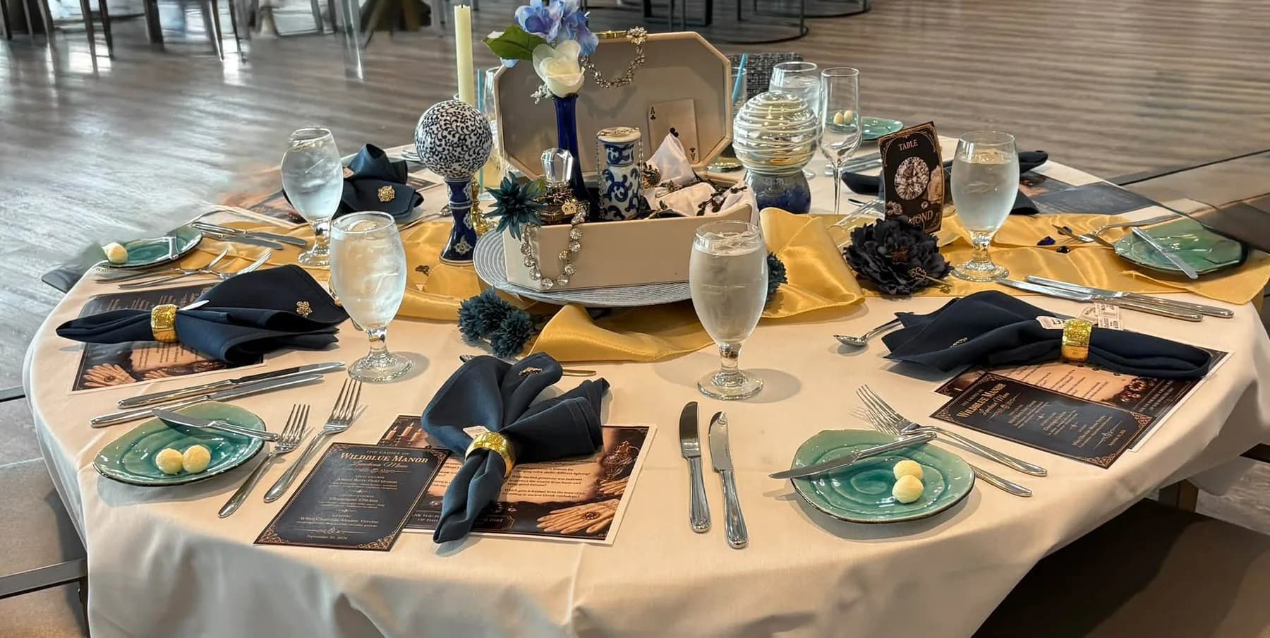 Gold runners and navy napkins surrounding a jewelry-box centerpiece
