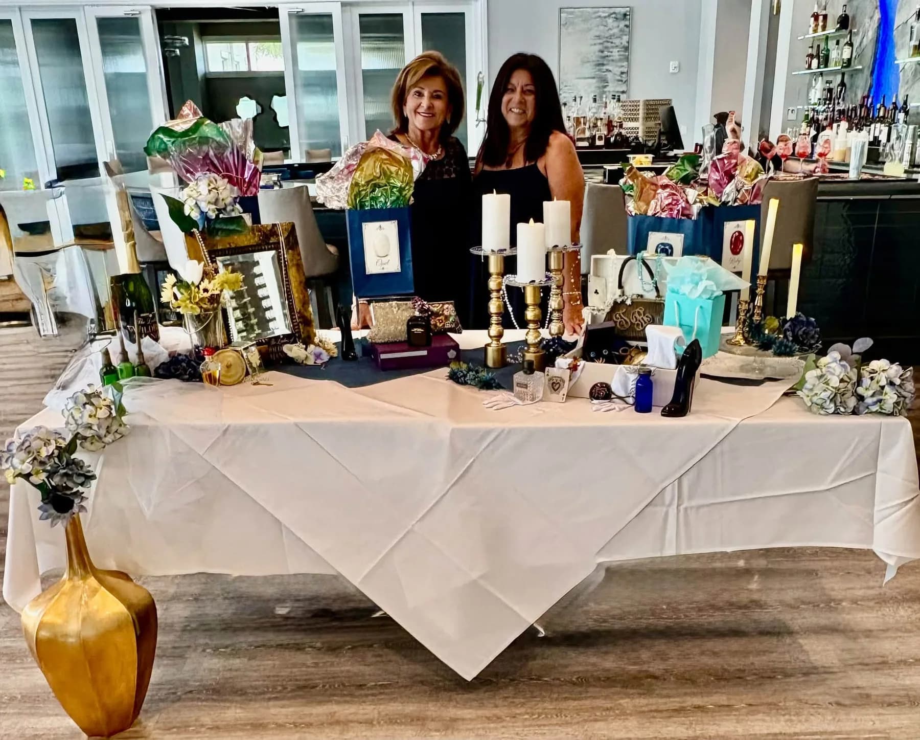Two guests standing behind a display of gift bags and candles