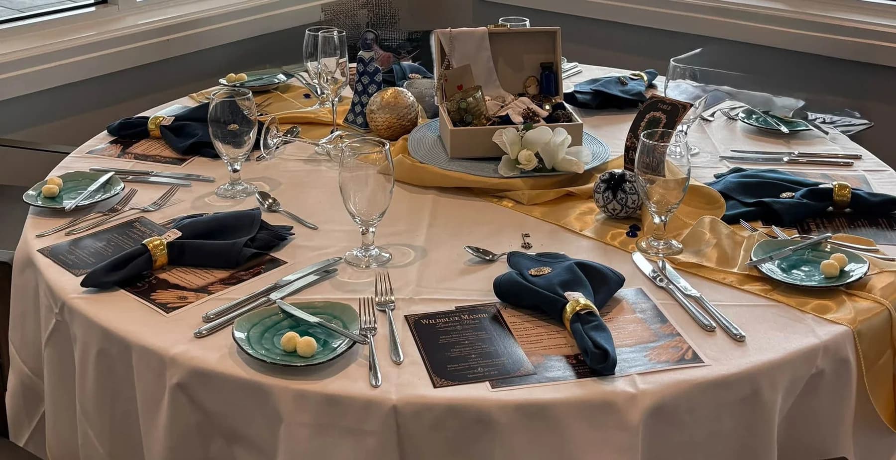 A round table with blue plates and navy napkins ready for guests
