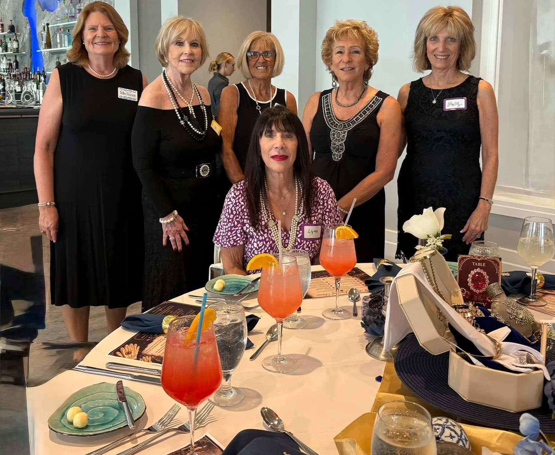 Friends smiling together behind a decorated luncheon table