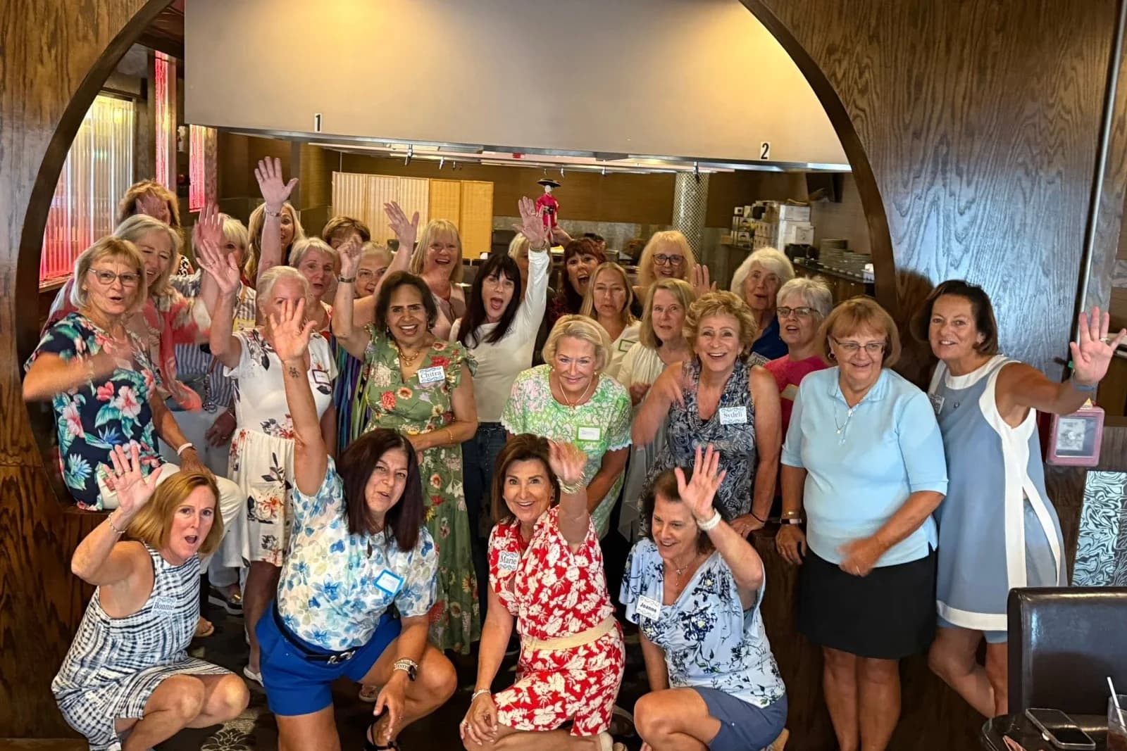 A large group of smiling WildBlue residents waving together